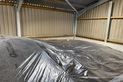 A grain heap sealed under polythene sheeting in a grain storage building